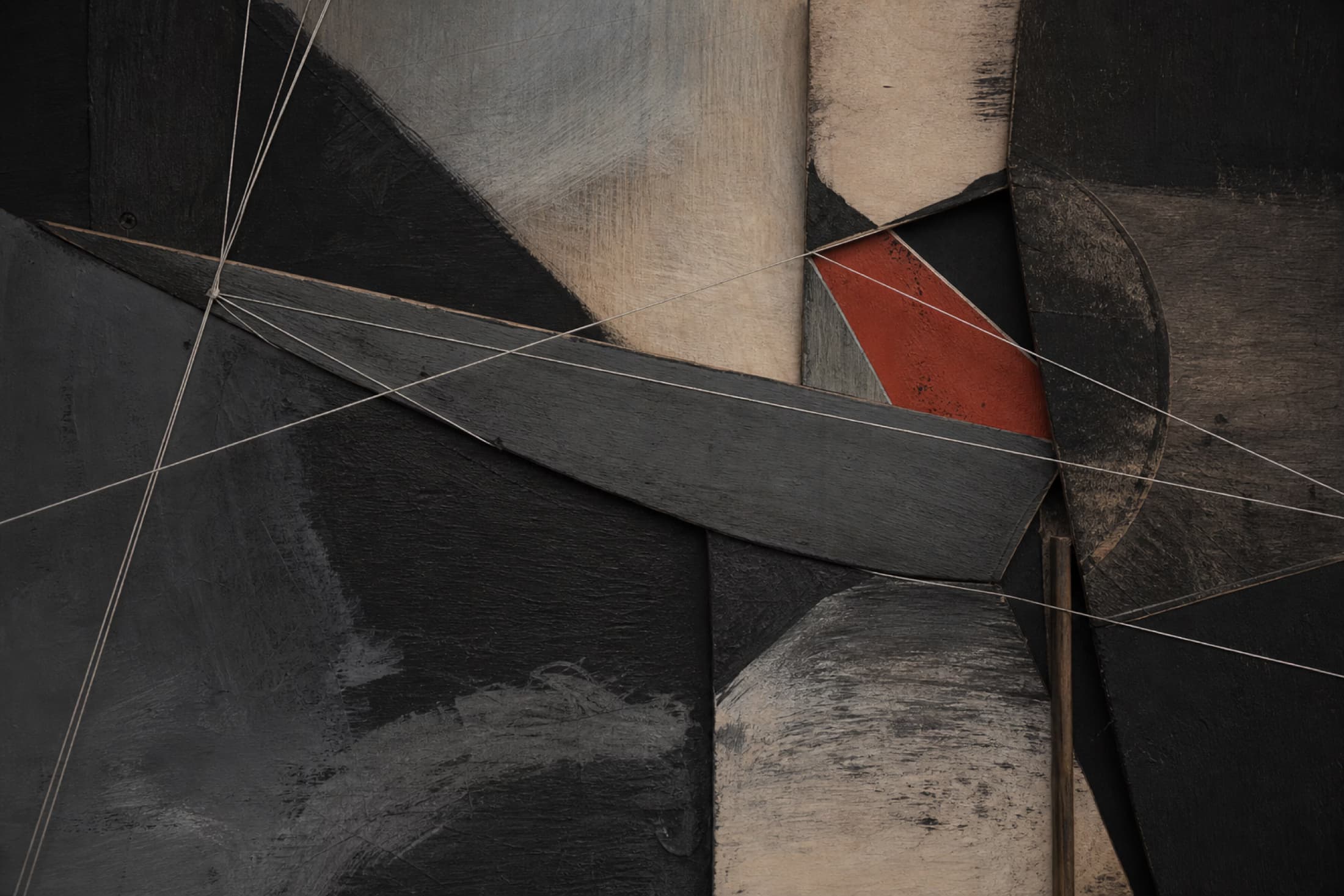 Abstrakte Mixed-Media-Arbeit auf Holz mit schwarzen Flächen, weißen Fäden und einem roten Akzent